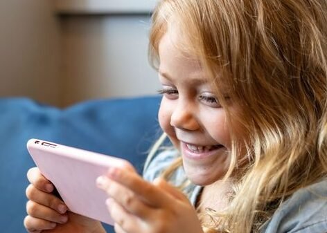 Little girl watching a movie on her phone…